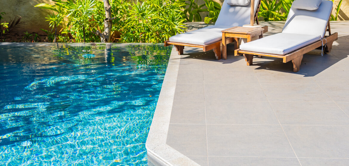 Umbrella and chair around outdoor swimming pool in resort hotel for vacation leisure