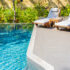 Umbrella and chair around outdoor swimming pool in resort hotel for vacation leisure